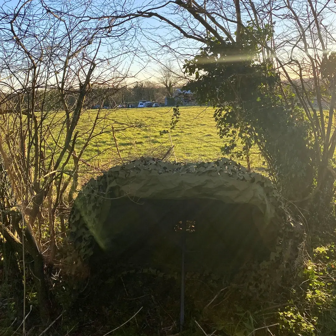 Stargazer Camouflage System hátulnézetből, álcázva a napsütötte mezőn.